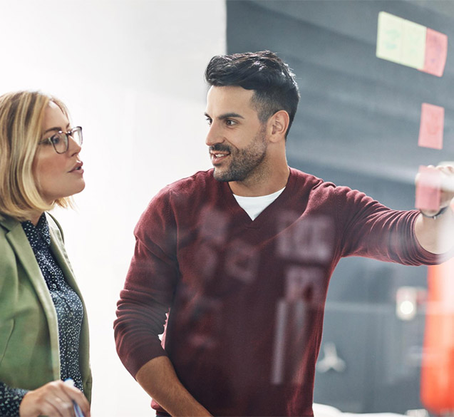 A man putting a sticky note on the wall