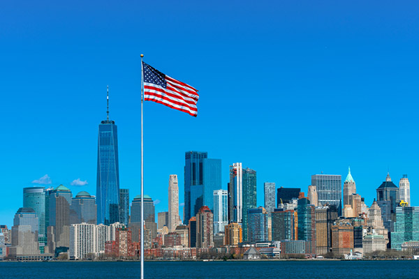 Picture of an American flag with a big city in the background