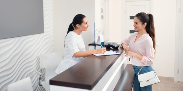 A woman checking in at the front desk of a spa