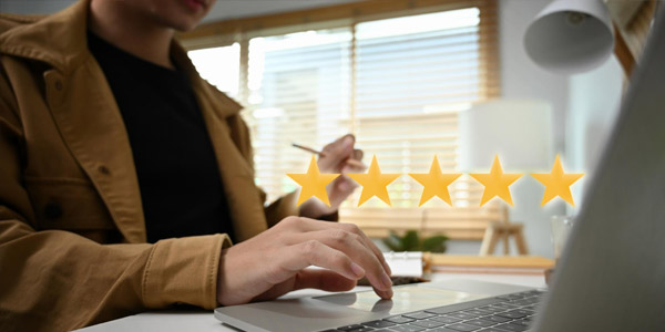 A man leaving a 5-star review on his computer