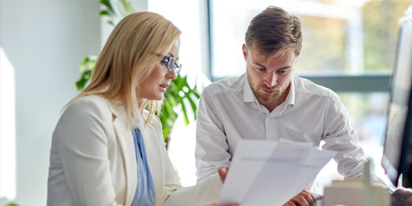 Man and woman looking at sheets of paper at an office