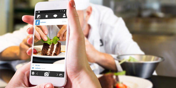A picture of someone taking a picture of a slice of chocolate cake