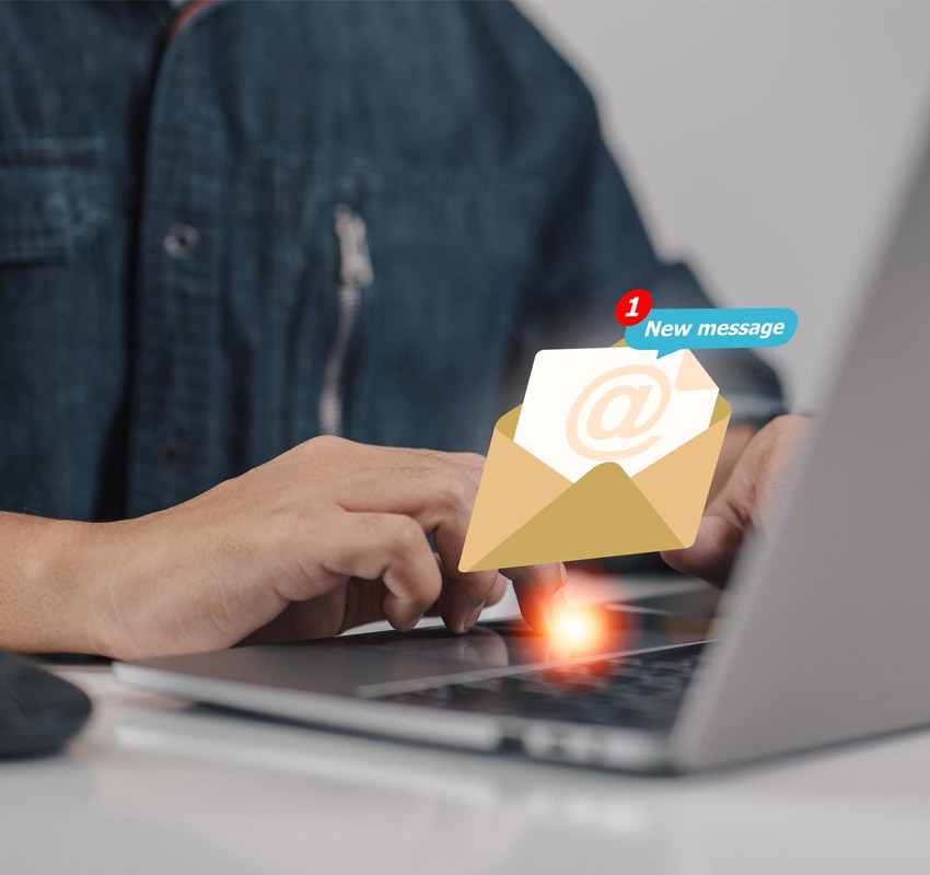 Person looking at computer with email icon floating above