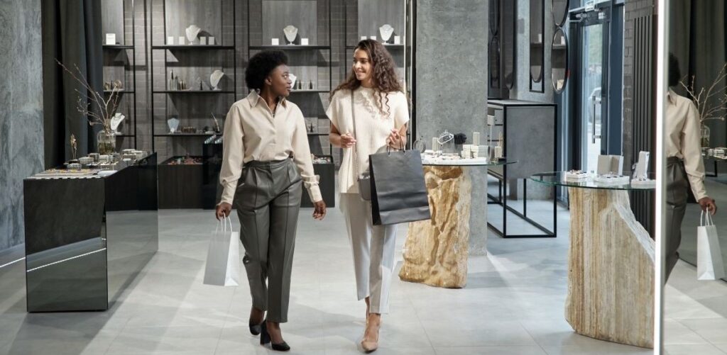 Two women in a clothing store holding shopping bags